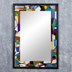 a mirror that is on the wall with some glass pieces in front of it,