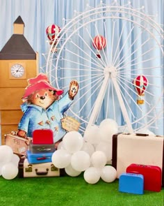 there is a ferris wheel and balloons on the ground next to some toys, including suitcases