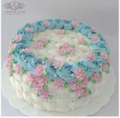 a cake decorated with blue and pink flowers on top of a white platter that says ateledocespaulausanzae