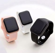 three smart watches sitting next to each other on a white surface with the same color band