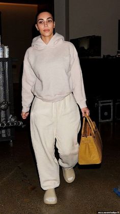 a woman carrying a handbag while walking through an airport