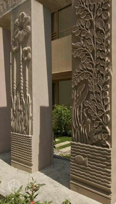 an intricately designed building with trees and flowers on the outside wall, in front of it