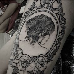 a woman's thigh with a mirror and flowers on it