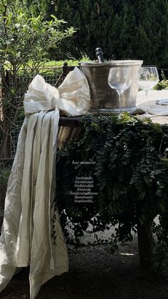 a table that has some wine glasses on it and a white cloth draped over it