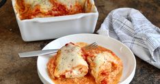 a white plate topped with lasagna next to a casserole dish filled with lasagna