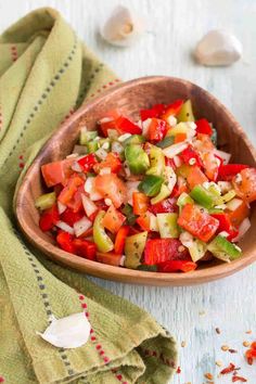 a wooden bowl filled with chopped vegetables on top of a table