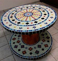 a multicolored table sitting on top of a tiled floor