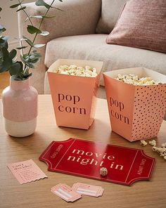 two pink boxes with popcorn on the table