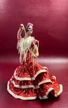 a figurine wearing a red dress with white polka dots