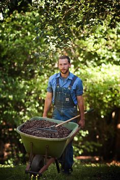 a man holding a wheelbarrow full of coffee beans