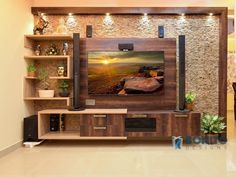 a living room with a large television on the wall and shelves in front of it