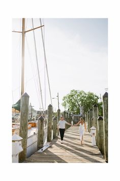 two people walking on a dock holding hands