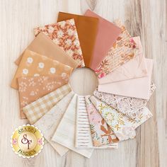 a bunch of different types of fabric on a wooden table with a gold badge that says american crafts & quilting