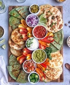 a platter with tortillas, salsa and guacamole