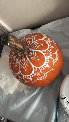 an orange pumpkin with white designs on it