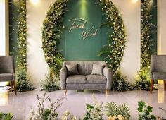 a couch and two chairs in front of a wall with greenery on it that says thank you