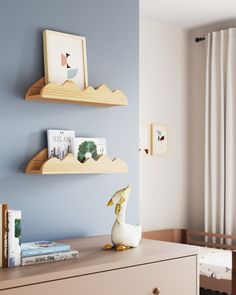 two wooden shelves on the wall above a dresser in a room with blue walls and white curtains