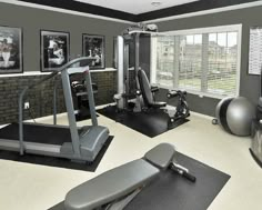 an exercise room is shown with treadmills, machines and other equipment in it