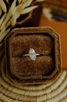 an engagement ring sits in a wooden box