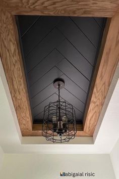 the light fixture is hanging from the ceiling in the room with white walls and wood paneling