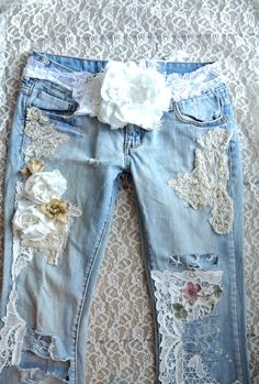 a pair of ripped jeans with flowers on the side and lace trims around the waist