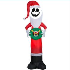 an inflatable santa clause holding a green ball with a monster on it's chest