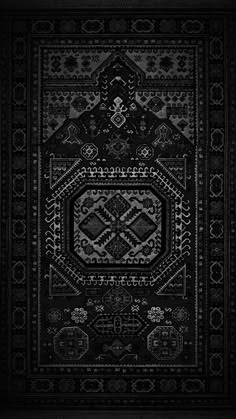 a black and white rug with an intricate design on the bottom, in front of a dark background