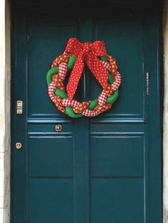 a green door with a red and white wreath on it