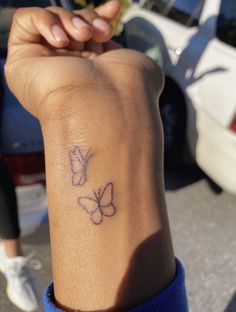 a woman's arm with a tattoo on it that has two butterflies on it