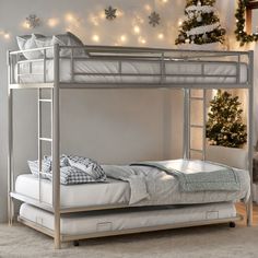 a metal bunk bed sitting in front of a christmas tree