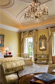 an elegant bedroom with chandelier, sofa and chairs