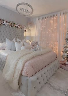 a bedroom decorated for christmas with white and pink decorations on the walls, lights hanging from the ceiling