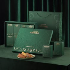 an assortment of green boxes and pastries on a table