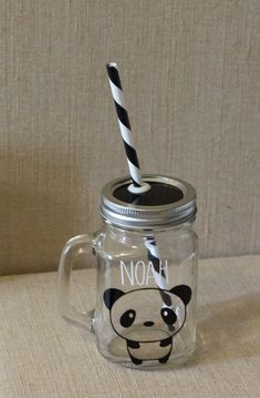 a glass mug with a straw in the shape of a panda bear and says noh