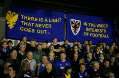 a large group of people standing next to each other in front of a blue banner