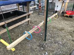 several different colored hoses on the ground in an outdoor area with hay and other items