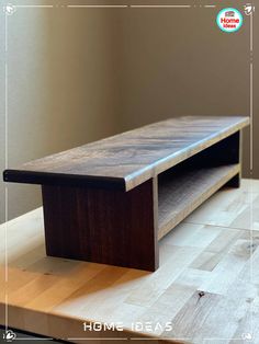 a wooden table sitting on top of a hard wood floor next to a wall and window