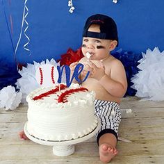 a baby sitting in front of a birthday cake