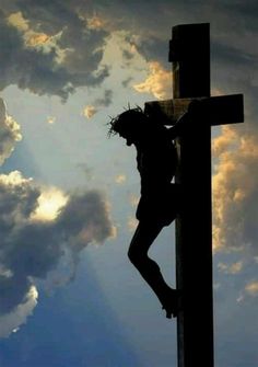 a man climbing up the side of a wooden cross