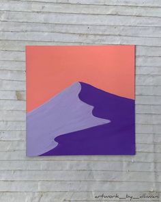 a piece of art that is on the side of a building with a mountain in the background