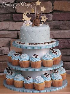 a three tiered cake with cupcakes on it