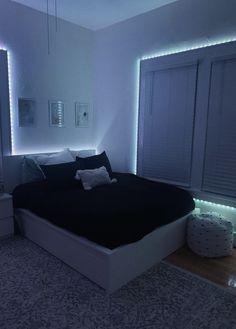 a large bed sitting in a bedroom next to a window with lights on it's sides