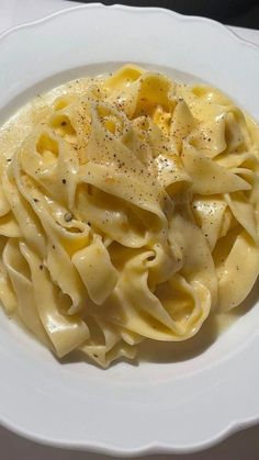 a white plate topped with pasta covered in sauce