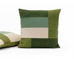 two green and white pillows sitting next to each other