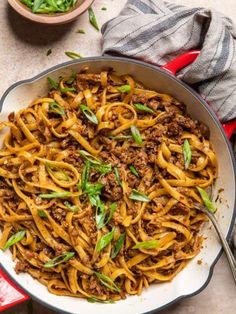 a skillet filled with pasta and meat