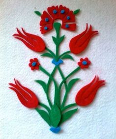 some red flowers and green stems on a white surface with blue dots in the middle