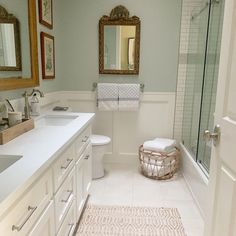 a bathroom with two sinks, a toilet and a shower