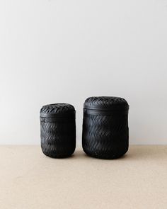 two black baskets sitting on top of a table