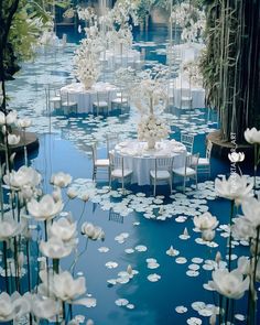 tables and chairs are set up in the water with white flowers