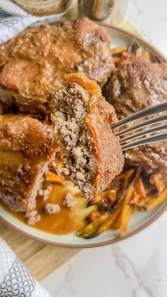 a piece of meatloaf on a plate with carrots and gravy